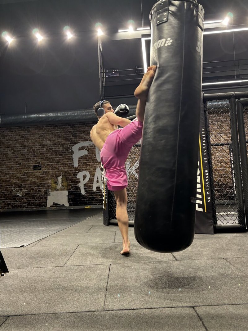 Mario, founder de Yaksha, high kick en cage MMA